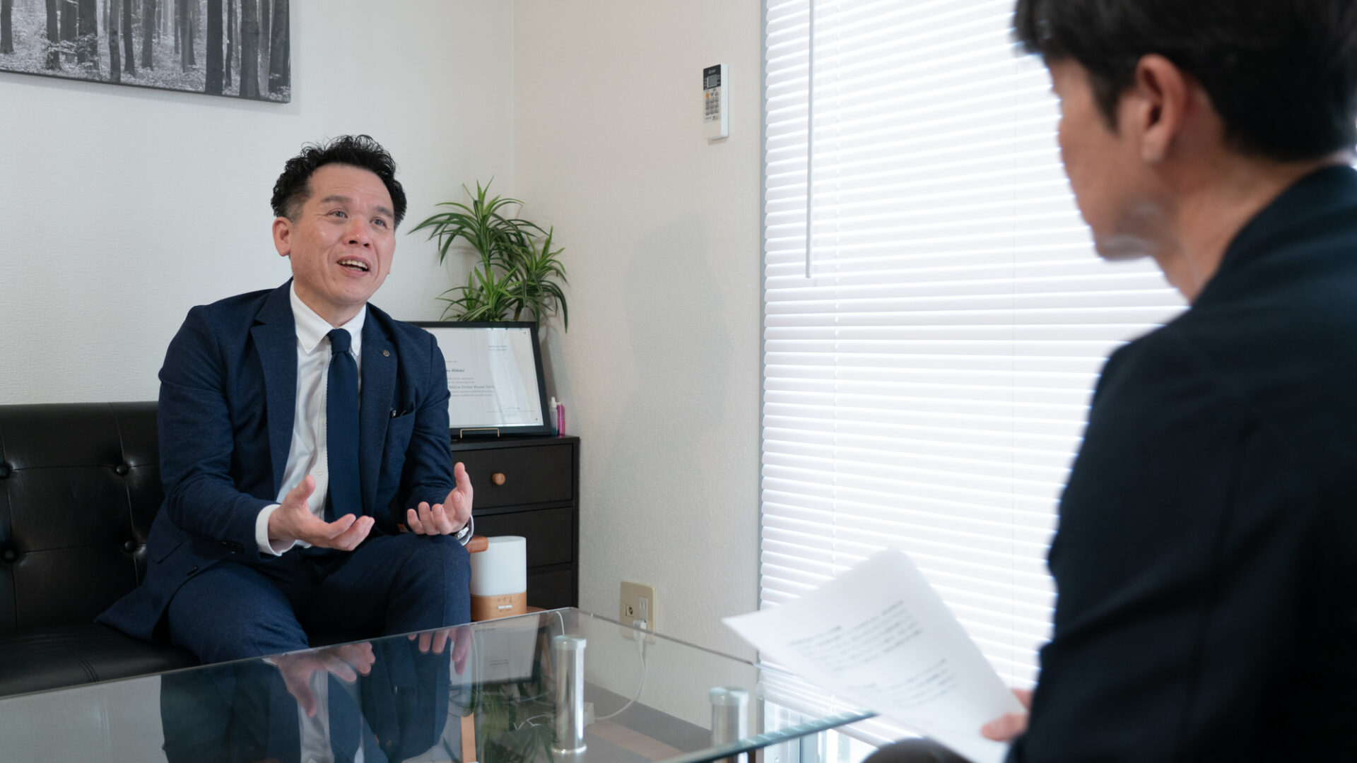 保険業界におけるWeb活用の意義と今後の展望について語る竹下健治氏と、それを聞く衞藤氏